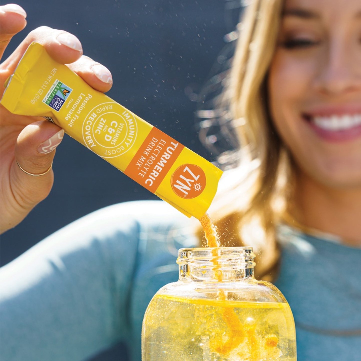 ZYN Electrolyte Drink Mix Passion Fruit Lemonade sachet being poured into a drink